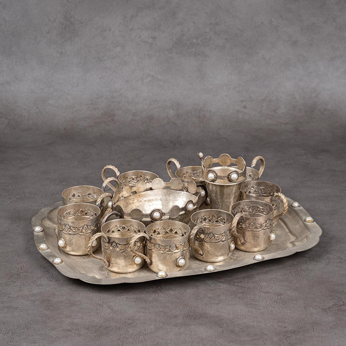 A hospitality set consisting of a tray, 10 cups, a glass, and a sugar bowl.