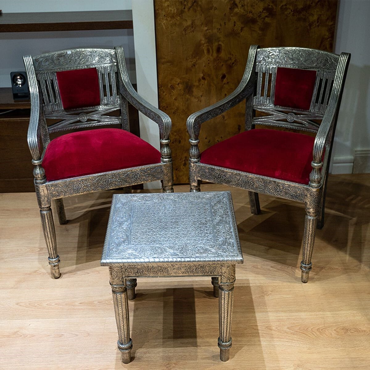 Two chairs and a table made of wood covered with silver-plated copper.