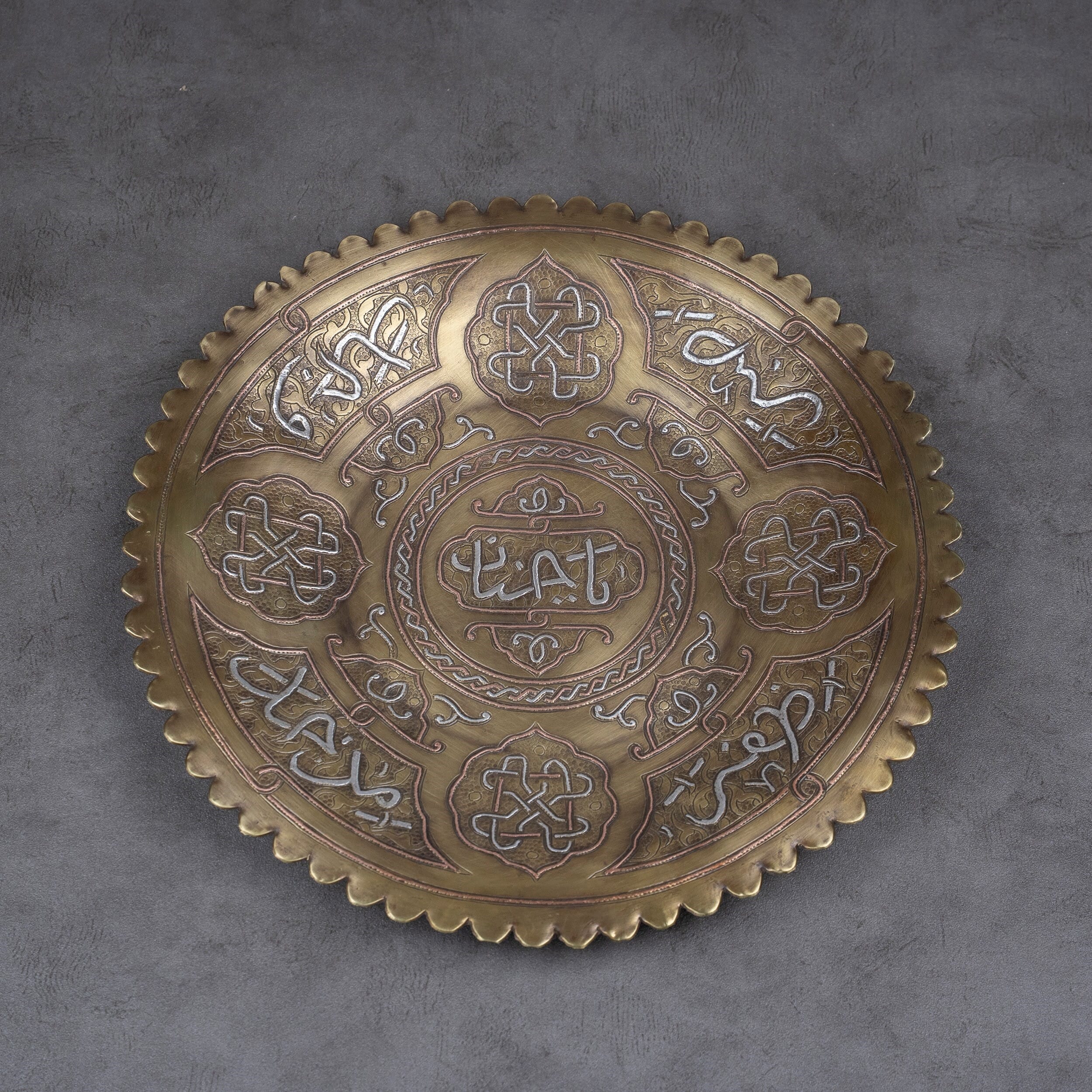 A plate made of brass inlaid with silver and red copper.