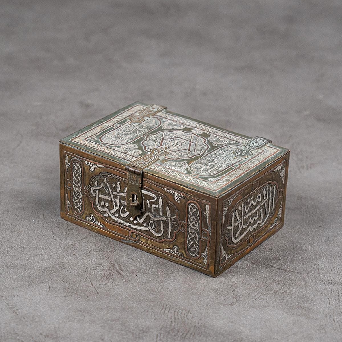 A brass box inlaid with silver and red copper on the outside and mother-of-pearl on the inside.
