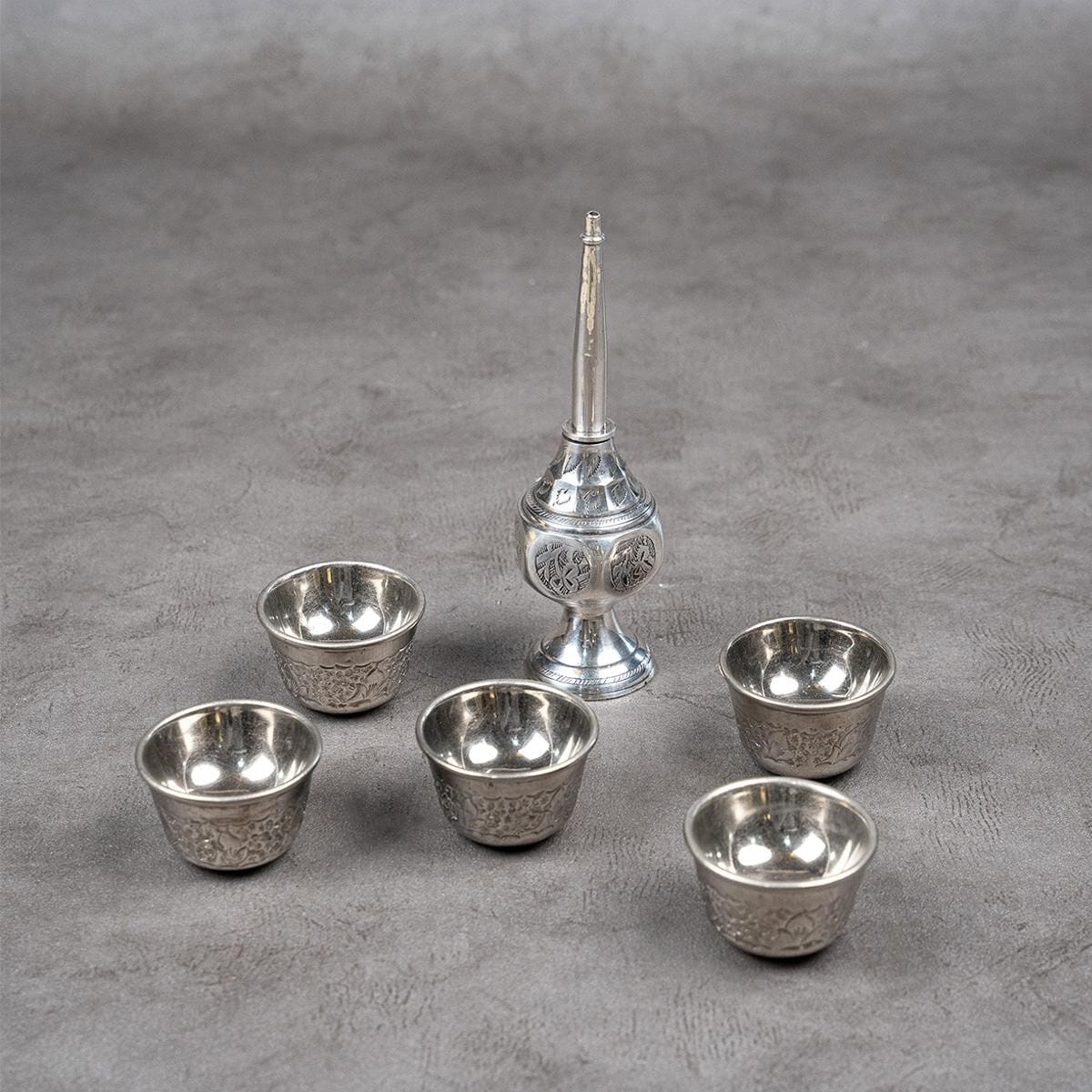 Five cups with a silver-plated brass jug.